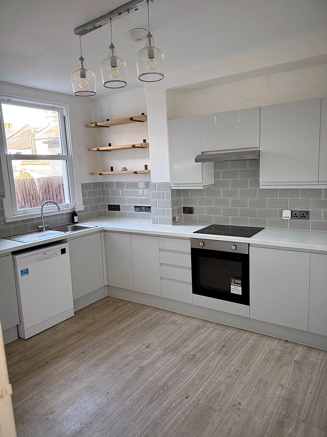 The finished kitchen with grey handleless units, metro tiles and pendant lights