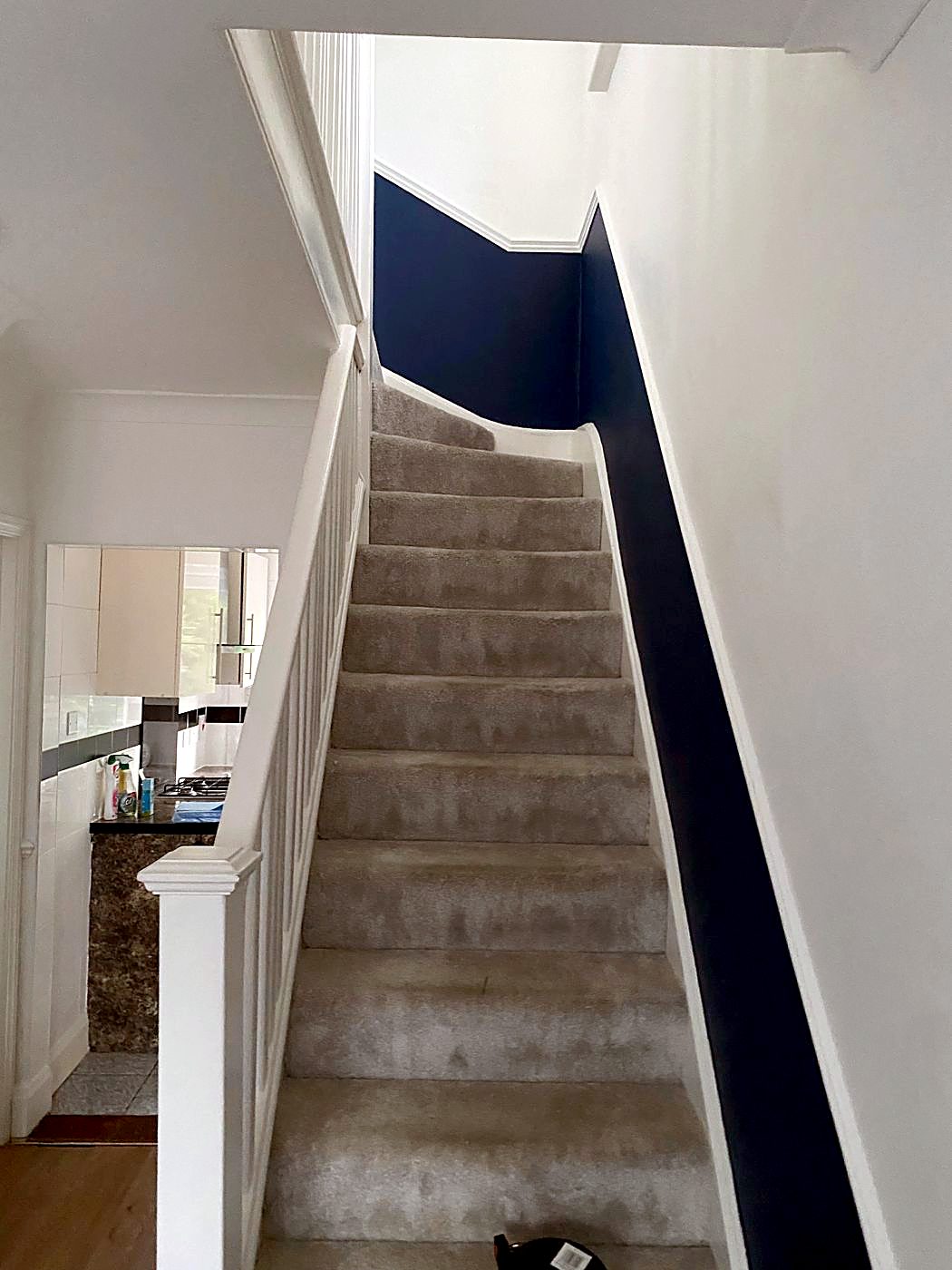 The same stairs after: new grey carpet and a navy feature wall