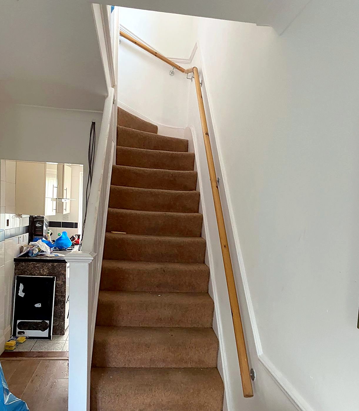 The hallway and stairs before: worn brown carpet and tired walls