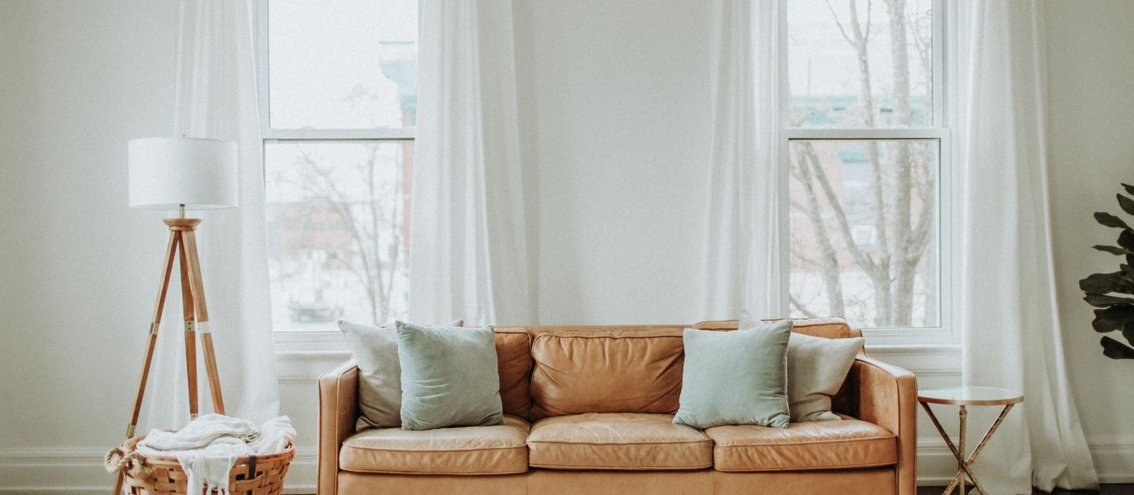 A bright living room with a sofa and tall windows