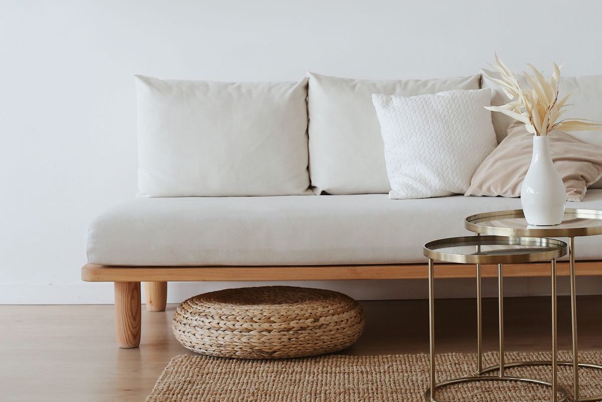 A calm living room with a white sofa and wooden floor